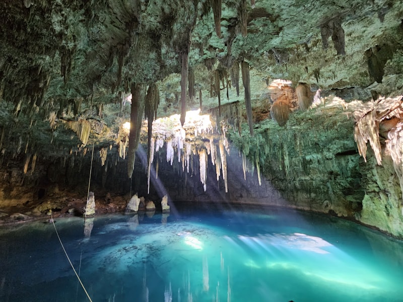 Cenote de agua turquesa en una cueva de roca caliza en Yucatán