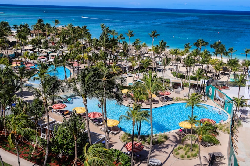 Resort con piscinas y palmeras frente al mar